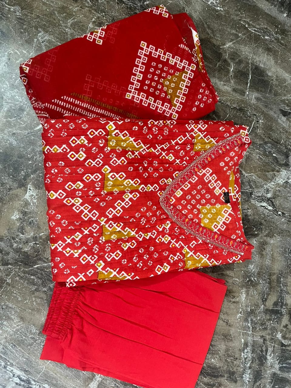 Radiate grace this Karwa Chauth in our finely crafted Red Cotton Suit with intricate embroidery and timeless Bandhani print all-over